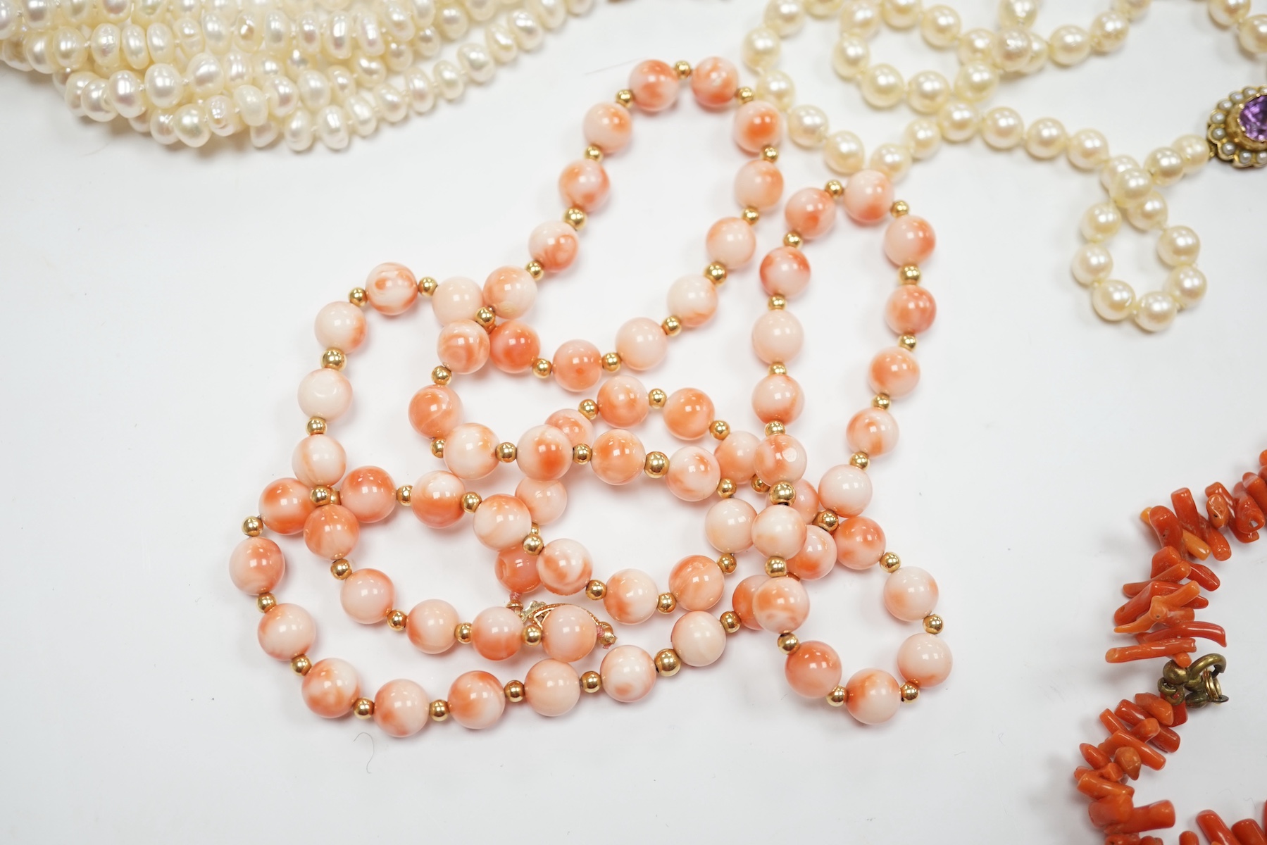 A modern five strand baroque pearl choker necklace with 14k clasp, 36cm, a single strand cultured pearl necklace, with gem set yellow metal clasp, a modern single strand coral bead necklace, two coral branch necklaces an